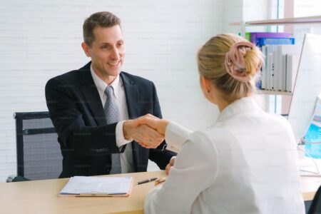 Job seeker and manager handshake in job interview meeting at corporate office. The young interviewee seeking for a professional career job opportunity . Human resources and recruitment concept.